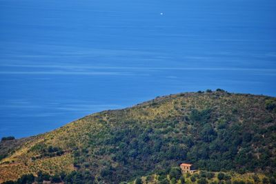 Scenic view of sea and mountains against blue sky