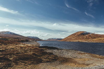 Scenic view of land and mountains against sky