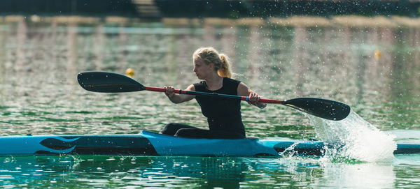 Young woman kayaking on lake