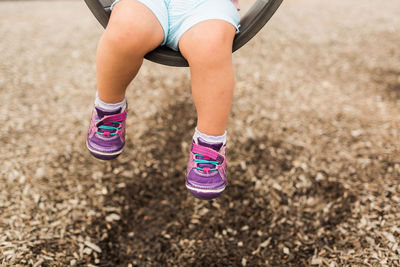 Low section of girl swinging at playground