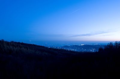 Scenic view of landscape against blue sky at night