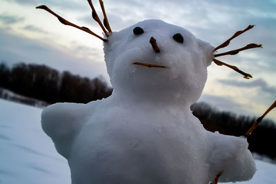 Close-up of frozen snowman against snow