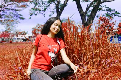 Young woman smiling while sitting on field