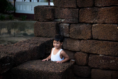 Portrait of a woman sitting against wall