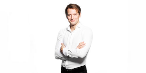 Portrait of man standing against white background