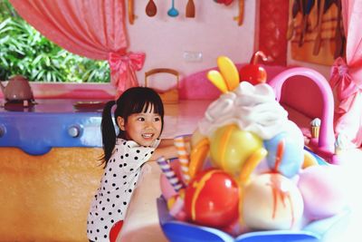 Side view of cute girl playing with toys at home