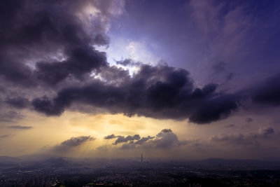 Scenic view of dramatic sky over city during sunset