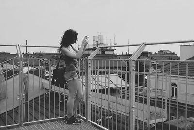 Full length of woman standing on railing