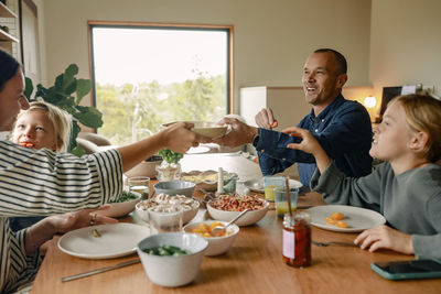 Happy family enjoying lunch on dining table at home