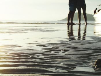 Low section of woman walking on beach