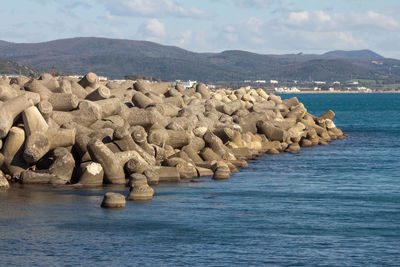 Rocks at sea shore against sky