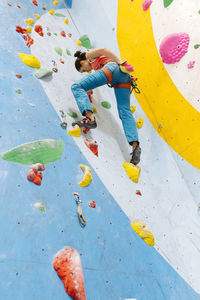 Low angle view of woman climbing on wall