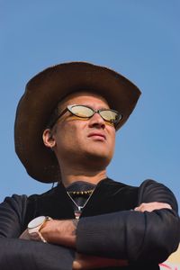 Portrait of young man wearing hat against sky