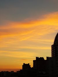 Silhouette buildings against sky during sunset