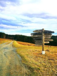 Road amidst field against sky