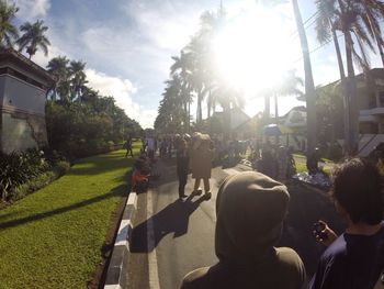 Rear view of people walking against sky