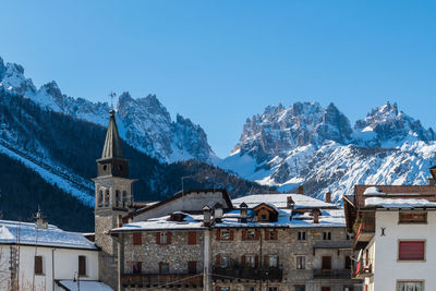 Buildings against clear blue sky during winter