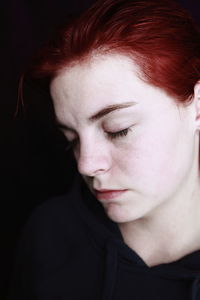 Close-up of beautiful woman against black background