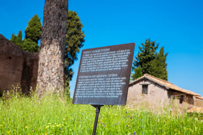 Information sign on field against sky