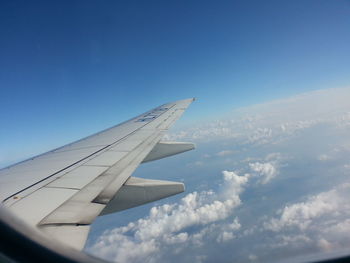 Airplane wing against clouds