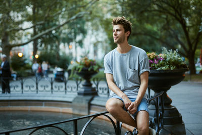 Young man sitting on bicycle in city