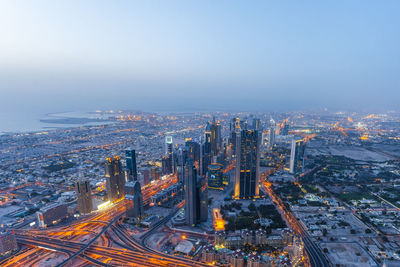 Aerial view of city lit up at waterfront