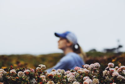 Close-up of flowering plants with woman in background