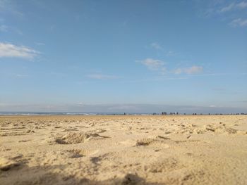 Scenic view of sandy beach against blue sky