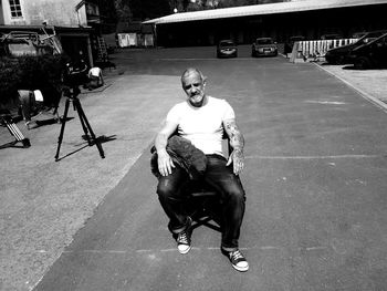 Full length portrait of young man sitting outdoors