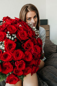 Charming young woman with a huge bouquet of red roses. flower delivery for holidays 
