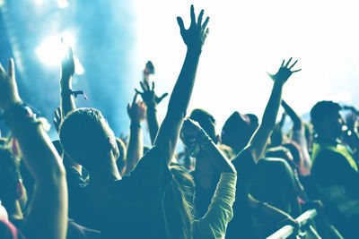 Rear view of crowd with arms outstretched at concert