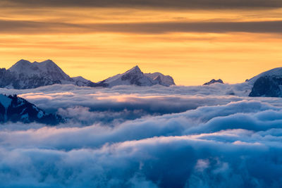 Scenic view of snowcapped mountains against sky during sunset