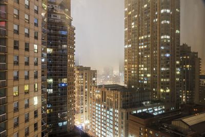 Illuminated cityscape against sky at night