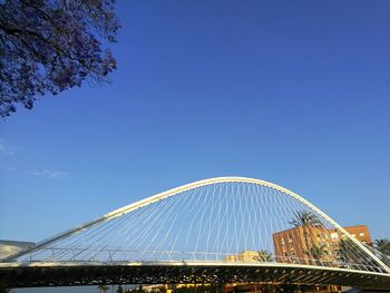 Low angle view of bridge against blue sky