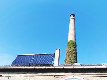 Low angle view of factory against clear blue sky