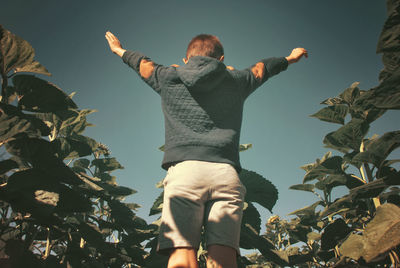 Low angle view of woman standing against sky