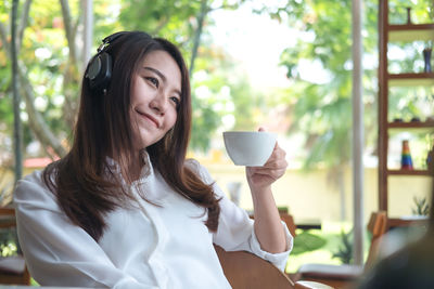 Woman listening music while drinking coffee cup