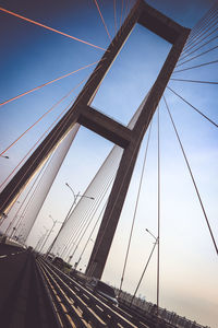 Low angle view of suspension bridge against sky