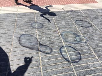 Low section of man shadow on tiled floor