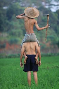 Back view of two farmers in a rice field