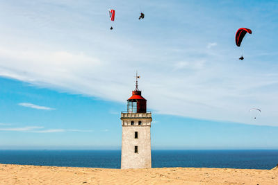 Low angle view of lighthouse by sea against sky