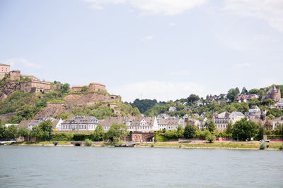 River by buildings in city against sky