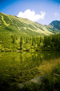 Scenic view of lake by mountain against sky