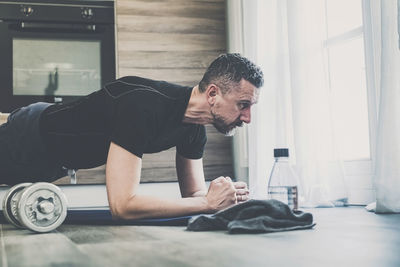 Man practicing plank exercise at home