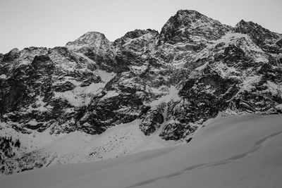 Low angle view of snowcapped mountain against clear sky