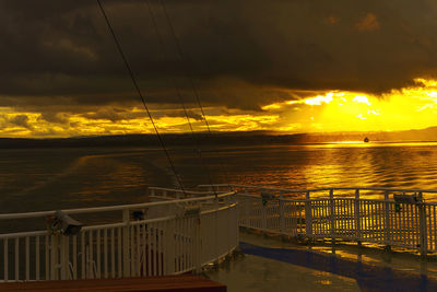 Scenic view of sea against dramatic sky during sunset