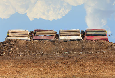 Abandoned stack on field against sky