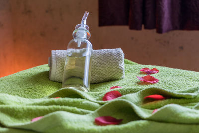 Close-up of spray bottle with towel on bed