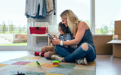 Side view of woman sitting on chair at home