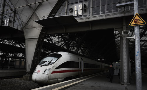 Train at railroad station in city against sky